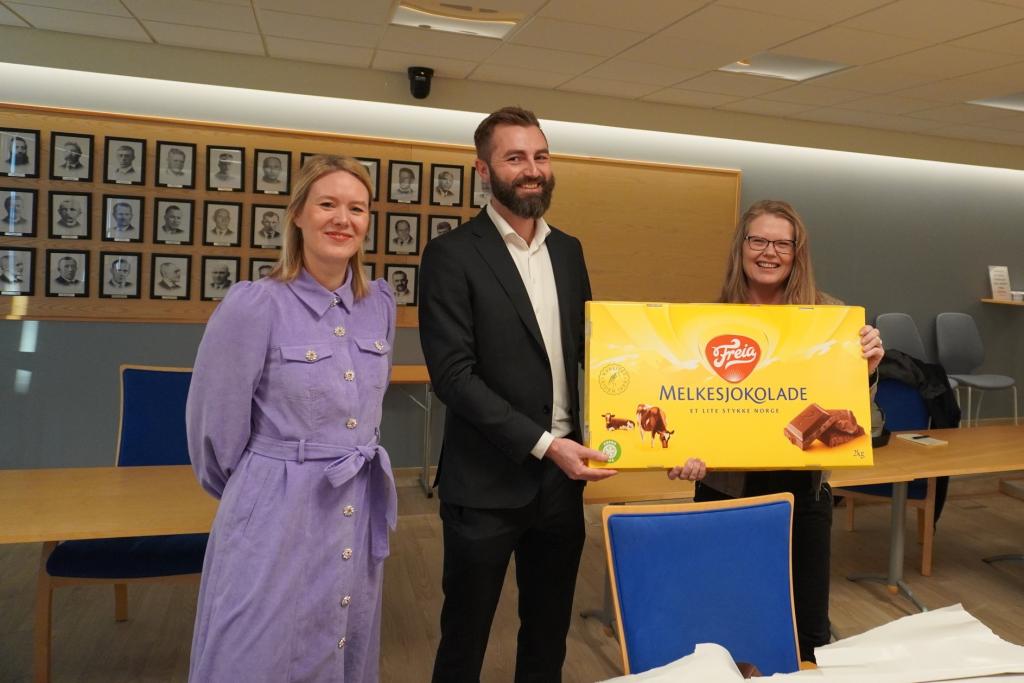 Margrethe Berg Goksøyr og Dag Ove Eggum frå tilsynet overrekker stor melkesjokolade til Line Helen Wedø Bårdsen i Frøya kommune.