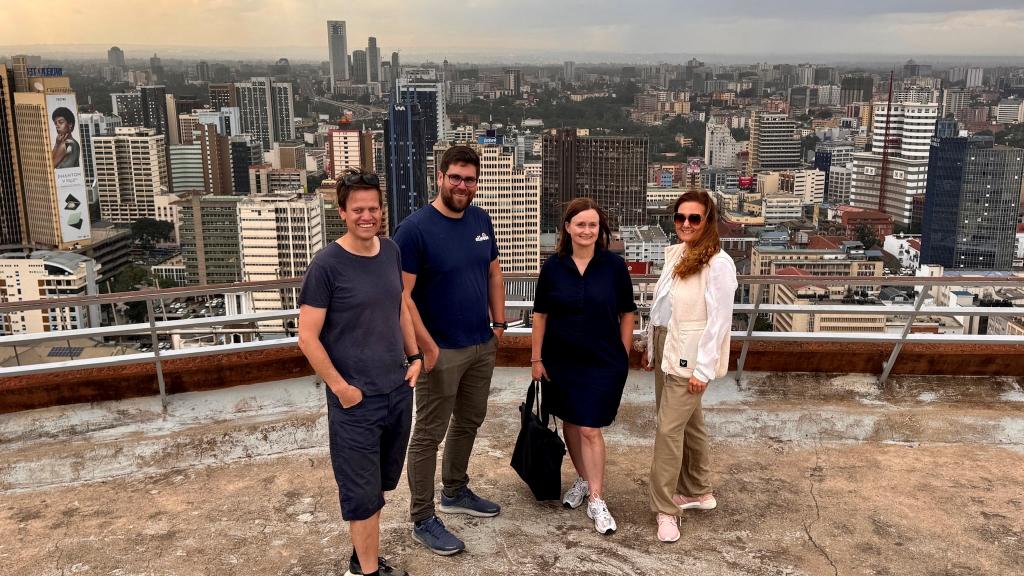 Espen Rørvik Tjøstolvsen, Adrian Husabø Bjørseth, Torhild Brudvik og Malin Rygg står sammen på toppen av Kenyatta International Convention Centre med Nairobi i bakgrunnen.