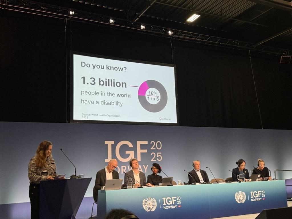Malin Rygg is giving a speech in the foreground. On the screen in the background it says "Do you know? 1.3 billion people in the world have a disability". In the panel behind her: Fredrik Matheson, Åsmund Grøver Aukrust, Irene Mbari-Kirika, Dan Sjöblom, Yu Ping Chan and Maja Brynteson.